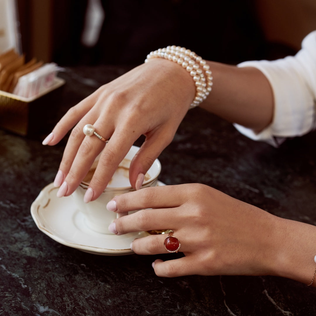Dettaglio mani con tazzina di caffè e gioielli con perle MIMI Milano – Look Domenica a Firenze